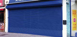 Powder coated blue steel galvanised roller shutter door used to secure a large retail unit.
