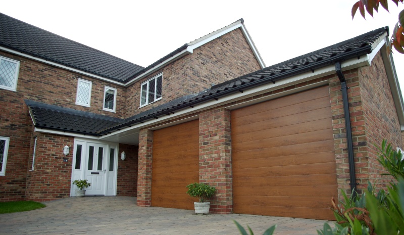 Golden oak retractable garage door providing security to domestic property.