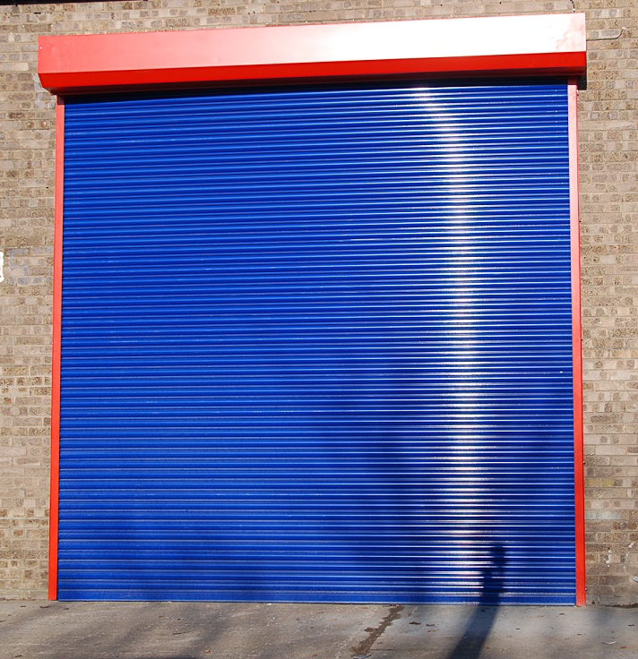 Birkdale galvanised industrial roller shutter doors powder coated blue fitted to an large industrial unit
