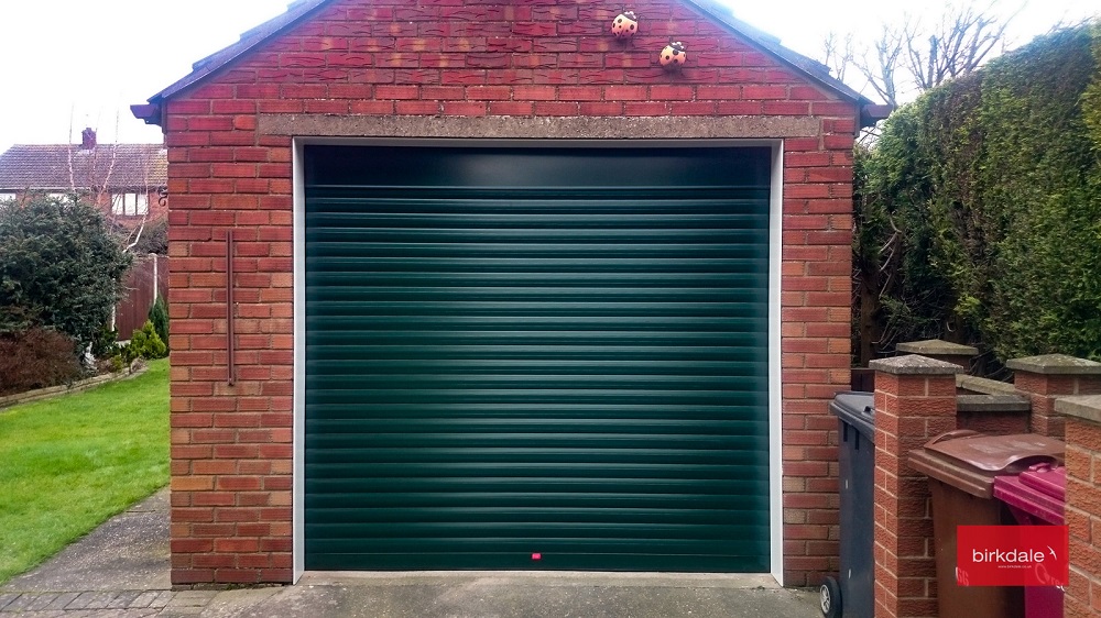 Dark green Birkdale insulated roller garage door fitted to detached brick built garage