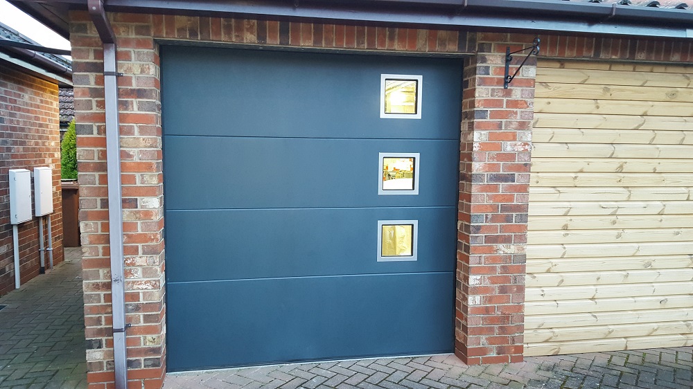 Flat panel Birkdale sectional garage door fitted with modern windows and painted in Anthracite Grey (RAL7016)