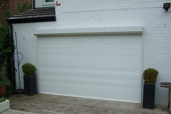 White compact insulated roller door fitted to the outside of a building in an external face fixed configuration.