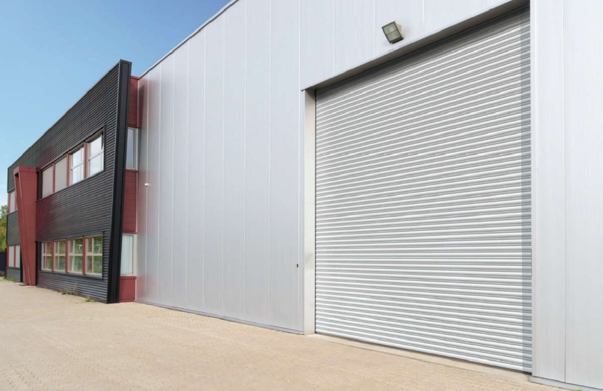 Galvanised industrial roller shutter door fitted to a large business premises.