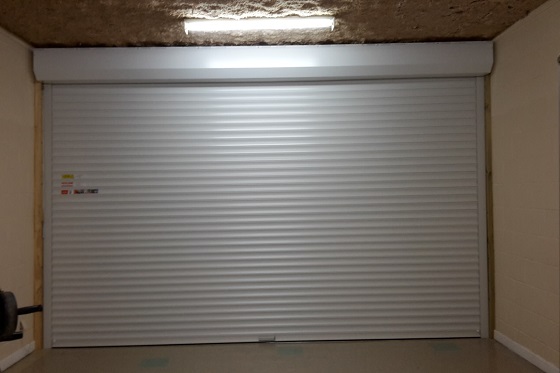 A view from inside a garage showing a roller door fitted in a face fixed configuration.
