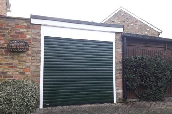 Dark green roller garage door fitted between the opening complete with full box and white guides.