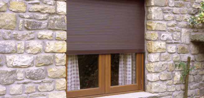 Powder coated extruded aluminium roller shutter used to protect a low level window from criminal activity.