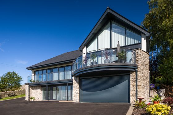 Double electric roller doors fitted to a modern detached house powder coated in a stylish anthracite grey.