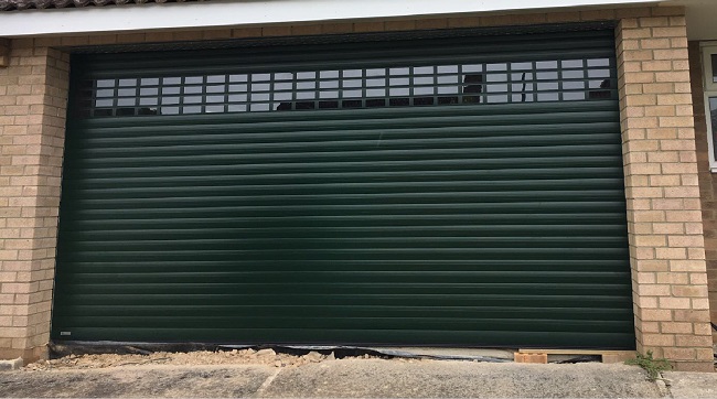 Fir green Seceuroglide garage door with vision windows fitted to new house in Gloucester, Gloucestershire.